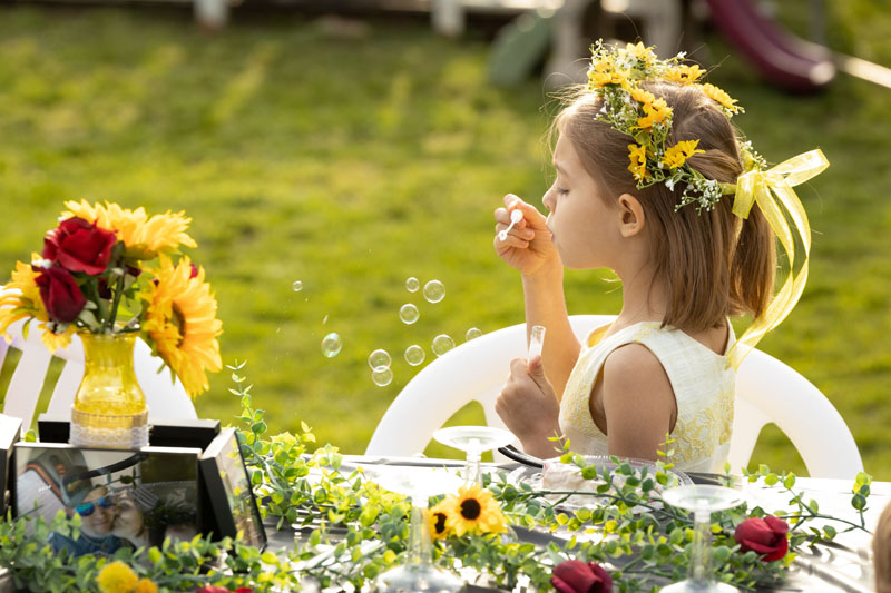 Country wedding reception and girl blowing bubbles