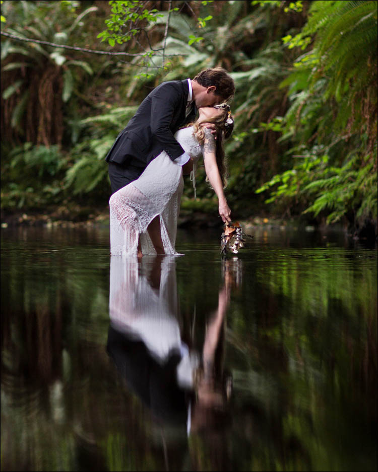 Redwood Weddings with bride and groom standing in a river after ceremony