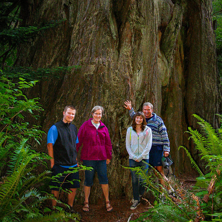 Redwood explorer Zane Moore and family by huge trunk